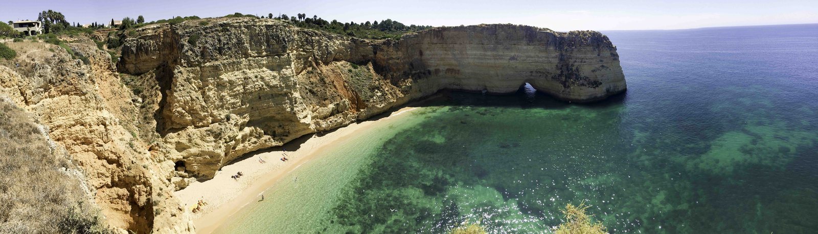 Une plage aux eaux turquoise, sa falaise ocre et son arche naturelle